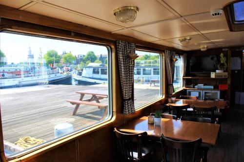 a restaurant with a table and chairs and a large window at Passengership Avanti in Amsterdam