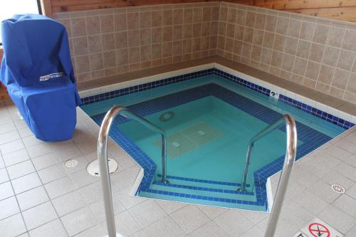 a swimming pool in a bathroom with a chair in it at Super 8 by Wyndham Antigo in Antigo