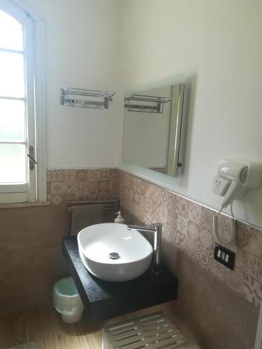 a bathroom with a white sink and a mirror at b&b le zagare in Caltanissetta
