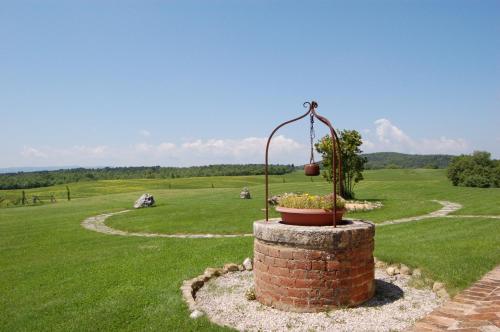 a brick pillar with a potted plant in a field at Locanda Vesuna Hotel Countryhouse in Pienza
