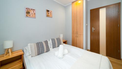 a bedroom with a white bed and a wooden cabinet at Apartamenty EverySky - Olimpijska 3 in Karpacz