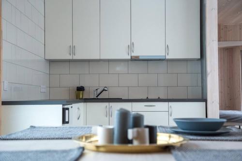 a kitchen with white cabinets and a table with dishes at TAURO TROBA “The Ox Shelter” in Stragutė