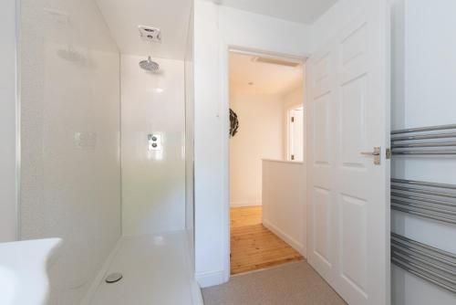 a bathroom with a shower and a white door at Riverside Cottage with sauna in Barnstaple