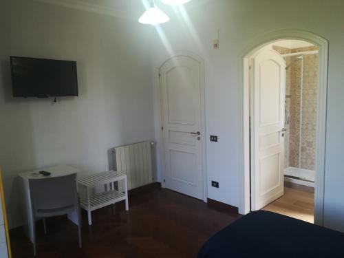 a room with a white door and a table and a tv at b&b le zagare in Caltanissetta