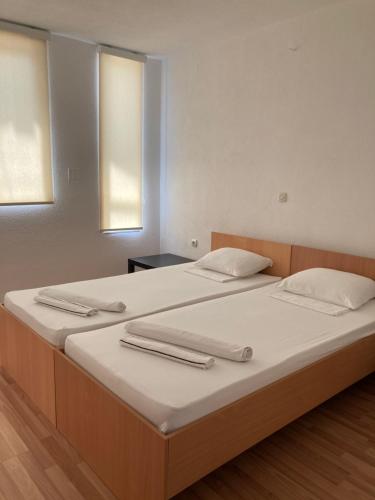 two beds in a room with two towels on them at TIKI Apartments in Gevgelija