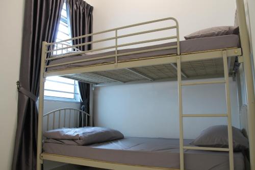 zwei Etagenbetten in einem Zimmer mit Fenster in der Unterkunft Bricks Terrace House 4R 3BR (Near to Night Market) in Brinchang
