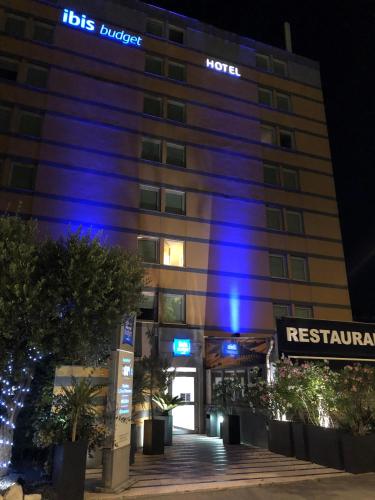 a hotel with blue lights on the side of a building at Hotel Ibis Budget Nice Palais Nikaia in Nice