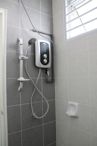 eine Dusche mit Haartrockner im Badezimmer in der Unterkunft Bricks Terrace House 4R 3BR (Near to Night Market) in Brinchang