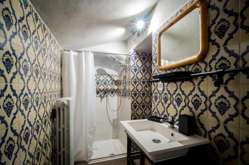 a bathroom with a sink and a shower and a mirror at La Spelonca degli Asini in Prata