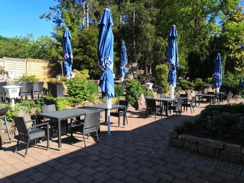 a group of tables with blue umbrellas and chairs at Zur Linde in Mainzweiler