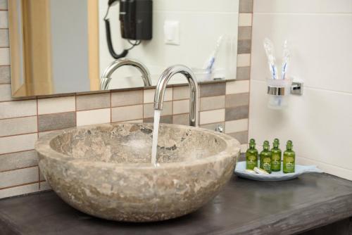 lavabo de piedra con grifo en el baño en Οasis Apartments en Amorgos