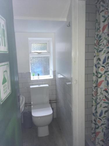 a bathroom with a white toilet and a window at Igloo Hybrid in Nottingham