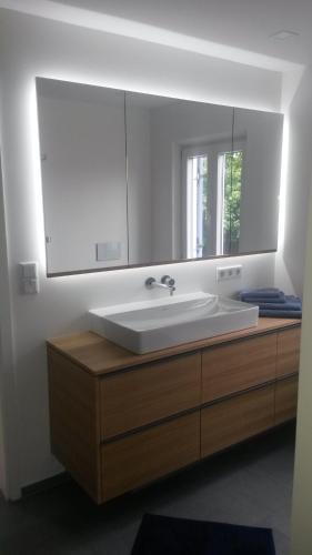 a bathroom with a sink and a large mirror at Ferienhaus Chiemsee in Übersee