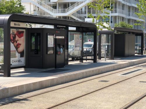 a bus stop with a woman on the platform at Hotel Ibis Budget Nice Palais Nikaia in Nice