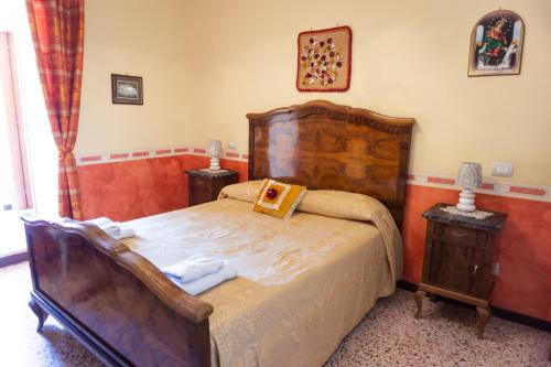1 dormitorio con 1 cama grande de madera y 2 mesitas de noche en B&B Fabiola, en Pompeya
