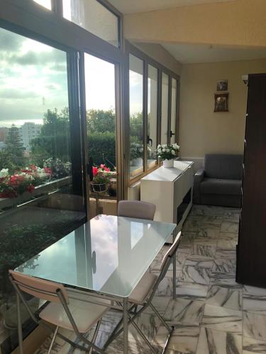 un salon avec une table en verre et des chaises dans l'établissement Résidence climatisée, belle vue, 5min de la plage., à Roquebrune-Cap-Martin
