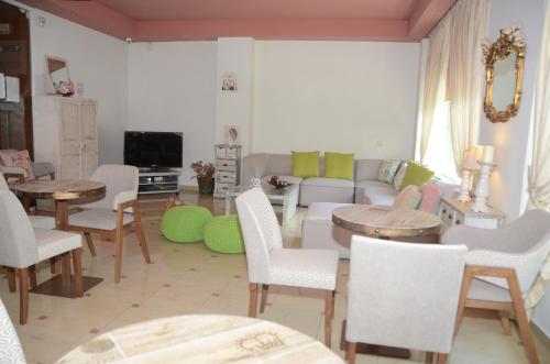 sala de estar con sofá, mesa y sillas en Ilion, en Loutraki