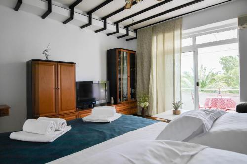 1 dormitorio con 2 camas blancas y TV en Apartment Beach Makarska, en Makarska
