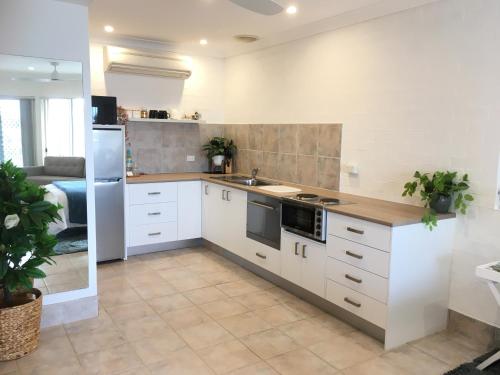 cocina con armarios blancos y encimera en SilverWaters Waterfront Accommodation en Morisset East