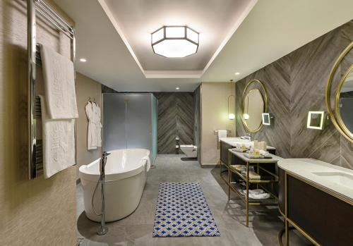 a bathroom with a tub and two sinks and a toilet at Elite World Grand Sapanca in Sapanca