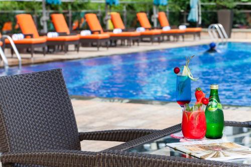 a table with two drinks on it next to a pool at Fraser Suites Guangzhou in Guangzhou