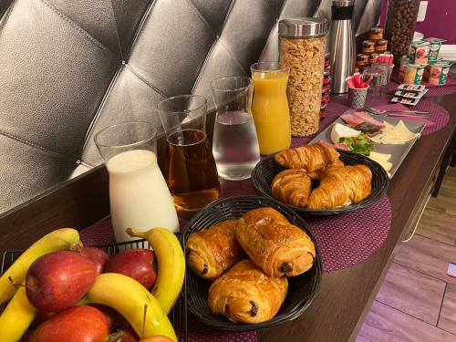 a table topped with plates of pastries and fruit at La cour des grands in Arras