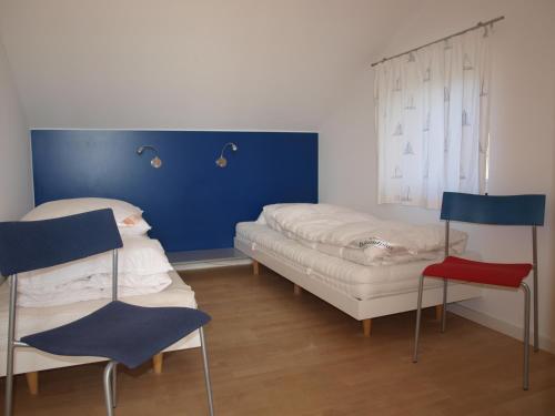 um quarto com uma cama, um sofá e cadeiras em Glashaus direkt am Müritzufer em Zielow