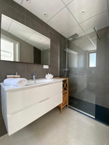 a bathroom with a large mirror and a sink at Aticos Concepción Centro in Córdoba