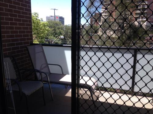 a screened in porch with a television and a chair at Strathfield Executive Accommodation in Sydney