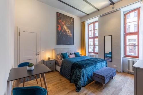 1 dormitorio con 1 cama, mesa y sillas en Loft Apartment Aqua, en Leipzig