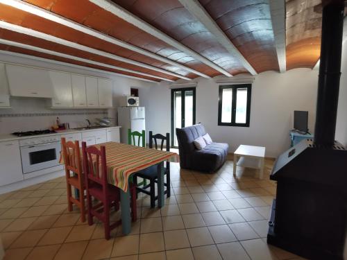 a kitchen and living room with a table and chairs at Lo Raconet in Sant Llorenç de Montgai