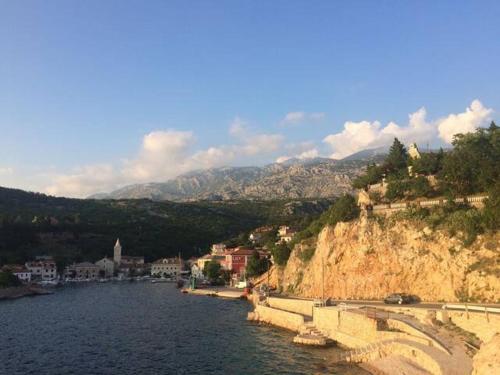 a large body of water next to a mountain at Wil Vannese in Stinica