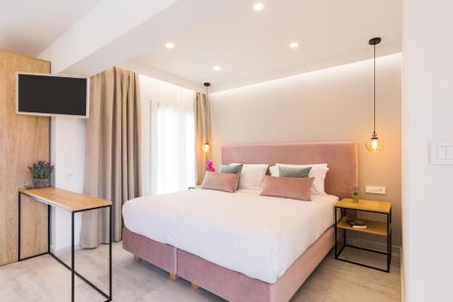 een slaapkamer met een groot bed en een televisie bij V Luxury Suites in (( Agía Eleoúsa ))