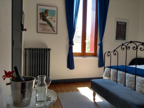 a bedroom with a bed with blue curtains and a table at Number15 Guesthouse Carcassonne in Carcassonne