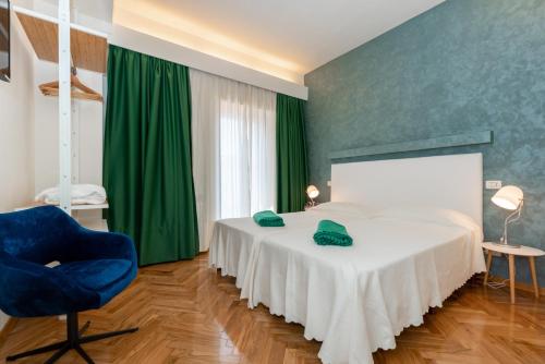 a bedroom with a white bed and a blue chair at Villa Oria in Pula