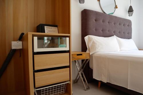 a bedroom with a bed and a dresser next to a bed at Hostal Boutique Olvido 22 Adults Only in Peñíscola