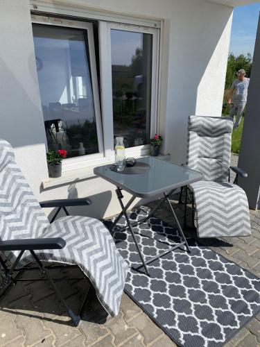 a patio with two chairs and a table and a table at Apartamenty "Marynarska " Rusinowo in Rusinowo