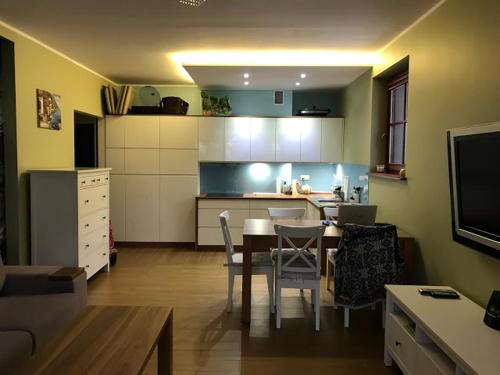 a kitchen and dining room with a table and chairs at Apartament Hania - Krynica Morska in Krynica Morska
