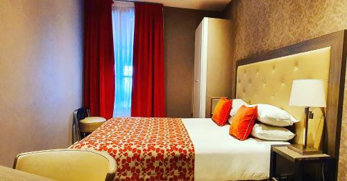 a hotel room with a bed and red curtains at Eiffel Kennedy in Paris