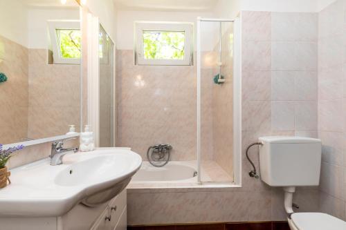 a bathroom with a sink and a shower and a toilet at Apartman Maya in Mali Lošinj