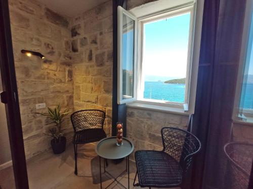 a room with two chairs and a table and a window at Hotel Korsal in Korčula