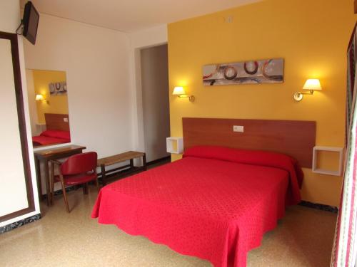 1 dormitorio con cama roja y escritorio en Hotel Miami, en Tossa de Mar