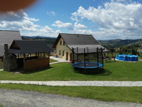 una casa con parque infantil y un edificio en Domki pod Beskidem, en Jaworzynka