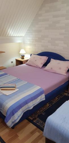 sypialnia z 2 łóżkami z różową i niebieską pościelą w obiekcie Smjestaj „Cubrilo" w mieście Herceg Novi