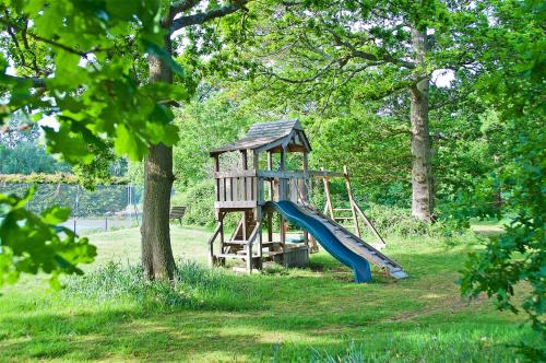 a playground with a slide in a park at Northlands Farm - Old Farm Cottage in Chichester