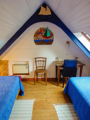 une chambre avec deux lits, une table et une chaise dans l'établissement Maison de la Ferme, à Lézardrieux