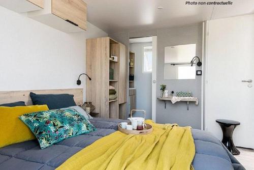 1 dormitorio con cama azul y manta amarilla en Martigues, Camping de l'Arquet ****, en Martigues