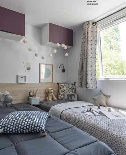 - une chambre avec 2 lits et un ours en peluche assis sur le lit dans l'établissement Martigues, Camping de l'Arquet ****, à Martigues