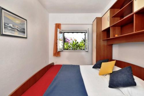 un dormitorio con una cama y una ventana en Villa Senjkovic - Apartments with Balcony and Sea View, en Bol