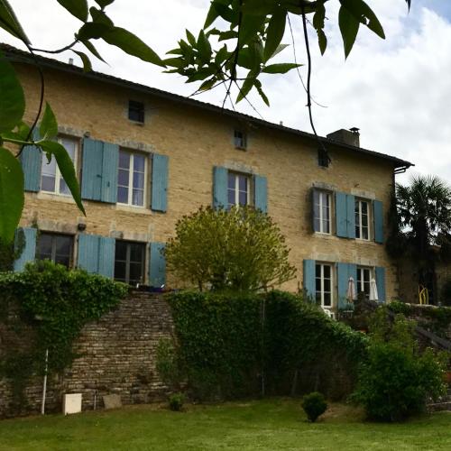 Une vieille maison avec des volets bleus dessus dans l'établissement The Mad Hatters Kitchen, à Chaunay